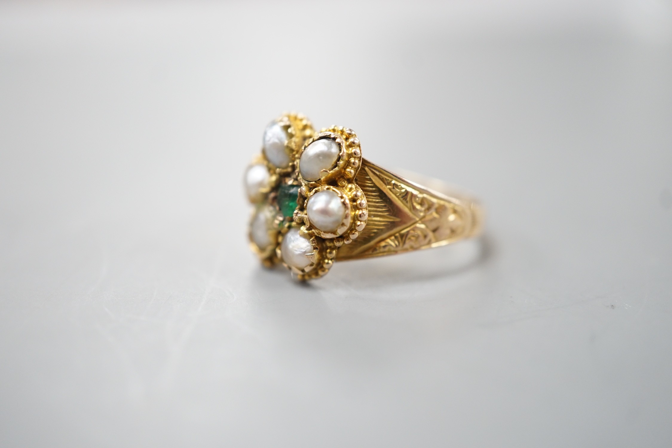 A late Victorian gold, emerald and split pearl cluster set ring, with later engraved inscription, size N, gross weight 2.9 grams.